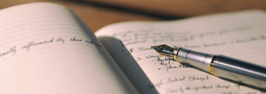A fountain pen open on a notebook